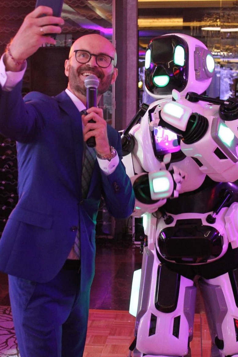 Friendly robot waving to a crowd of attendees